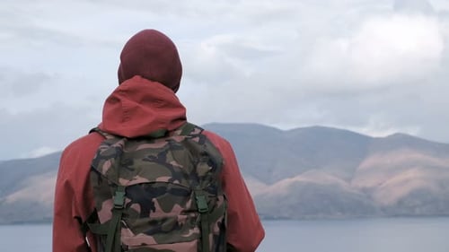 Person with Backpack Looking Out at Mountain Vista