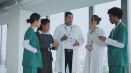 Medical Staff in Uniform Discussing Working Plan in Clinic Blurred