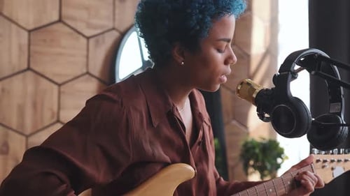 Woman Playing Electric Guitar and Singing at Home