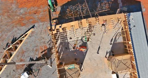 Baurahmensparren werden mit einem Kran auf einem unfertigen Holzhaus installiert