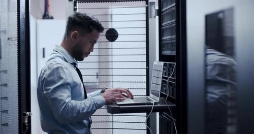 Young Adult Working on Laptop in Data Center
