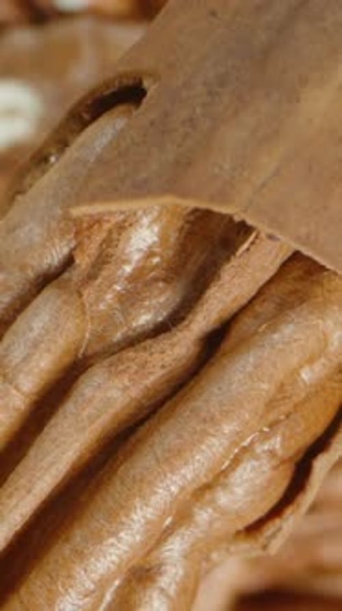 Vertical video. Pecan falls onto the table, and the camera focuses on the distant background.
