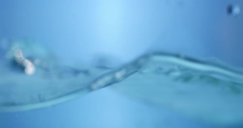 Erfrischende blaue Wellen. Abstrakter Wasserhintergrund mit spritzenden Blasen. Ansicht des Süßwassertröpfchens