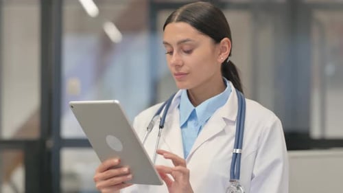 Young Woman Doctor Using Tablet in Hospital Office