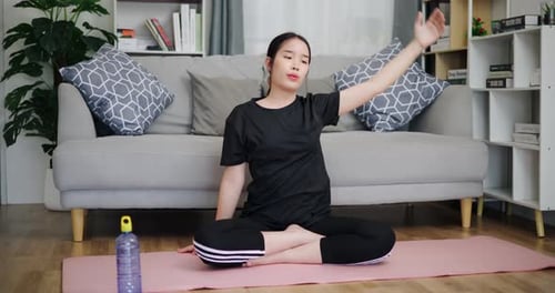 Young Woman Stretches on Yoga Mat at Home