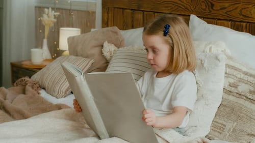 Cute Little 5s Caucasian Alone Child Girl Daughter Looking in Book Kid Preschool Baby Sitting in Bed