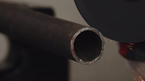 Closeup of Metal Pipe That is Being Sawed By an Angle Grinder with Cutting Disc Sparks Everywhere