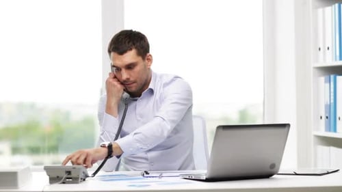 Business, People, Paperwork and Technology Concept - Businessman with Laptop Computer And