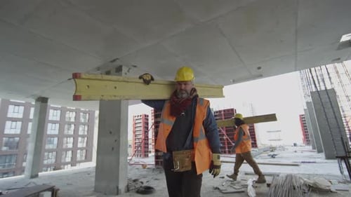 Construction Worker Carrying Plank while Building Real Estate