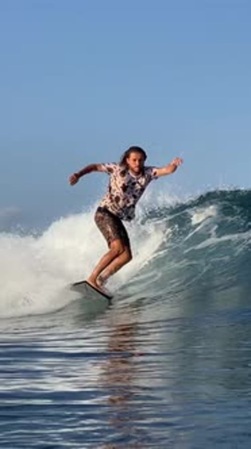 Young Guy Surfs in the Ocean