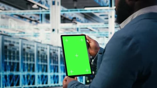 Greenscreen-Mockup-Tablet im Serverraum, das von Mitarbeitern zur Verbesserung der Hardware verwendet wird