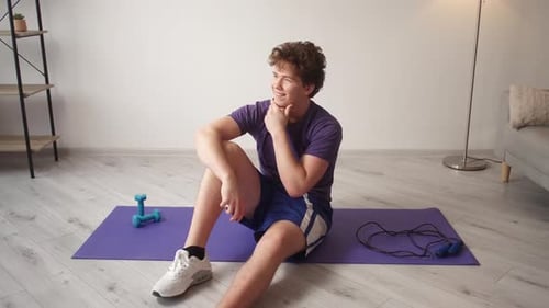 Young Man Resting After Home Workout Indoors