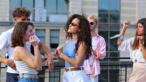 Happy Friends Laughing on City Rooftop in Sunlight