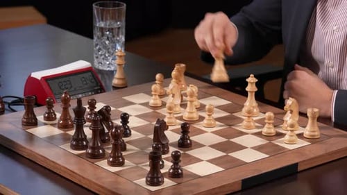 Zwei Menschen, die nicht wiederzuerkennen sind, spielen Schach und einer ist dabei, den König zu werfen.