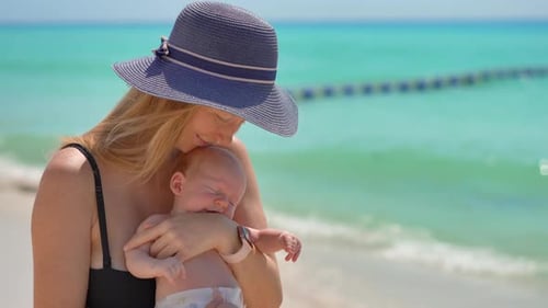 Mother and Newborn Son at the Beach on a Sunny Summer Day Closeup of a Loving Mom Holding Her Baby
