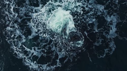 Les eaux de l'océan tourbillonnent autour de la côte rocheuse et pittoresque, les vagues de la mer se brisent sur les rochers