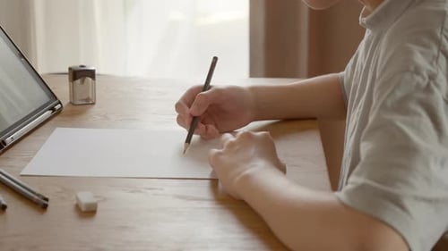 Kinderhände zeichnen vorsichtig eine Skizze mit einem Bleistift auf ein weißes Blatt Papier