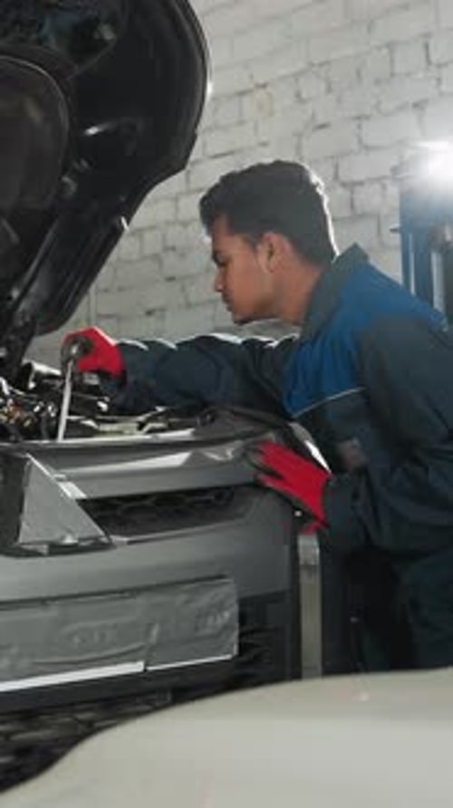 Des mécaniciens réparent le moteur de la voiture dans un atelier bien éclairé
