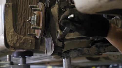 Closeup of a Wheel Repair at a Service Station an Auto Mechanic Uses a Wrench