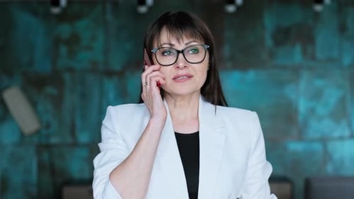 Closeup of Mature Business Woman Talking on Mobile Phone in Office