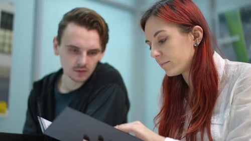 Colleagues Reviewing Documents in Bright Office Setting