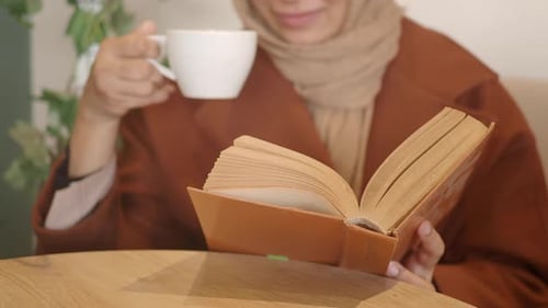 Enjoying a Cozy Reading Moment with Tea in a Cafe