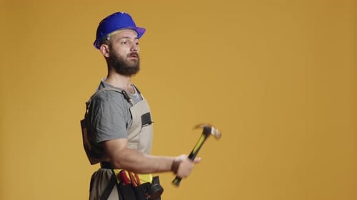 Construction Worker Using Manual Hammer to Hit Nails in Wall