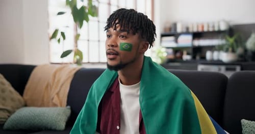 Victory, cheer and football fan in house with flag, goal excitement or celebration in sports
