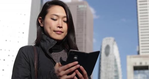 Japanese female using smart phone in Tokyo, Japan