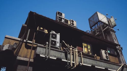 Urban Building Adorned with Multiple Air Conditioning Units Against a Clear Sky