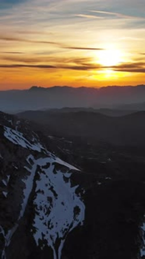 Rocky snow mountains and sunset sun