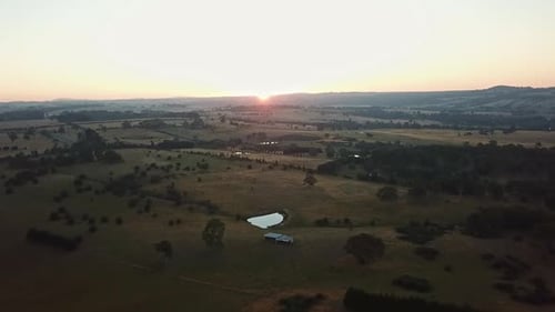 Aerial footage looking into the sun of a rural landscape near Tylden, central Victoria, Australia. J