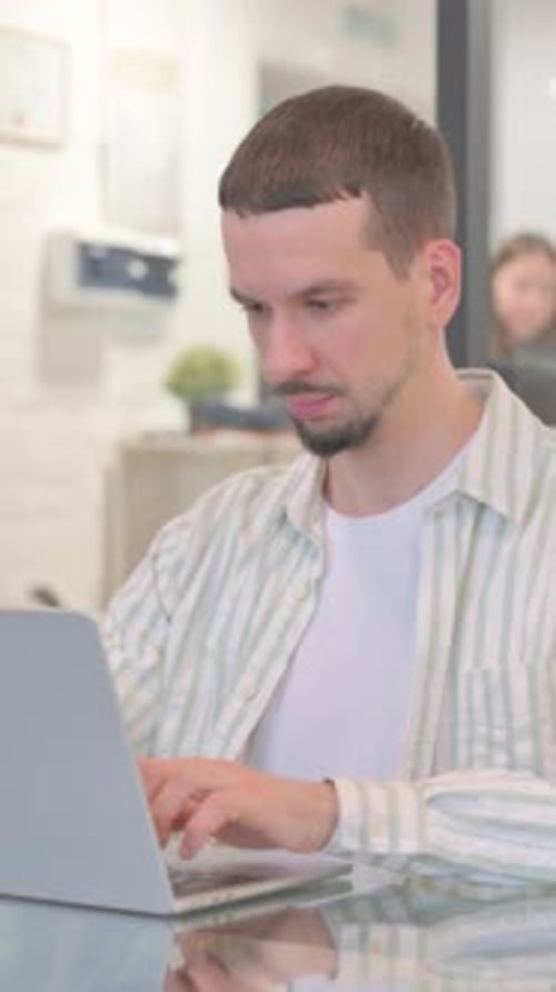 Surprised Creative Young Man Wondering while Looking at Camera in Office, vertical video
