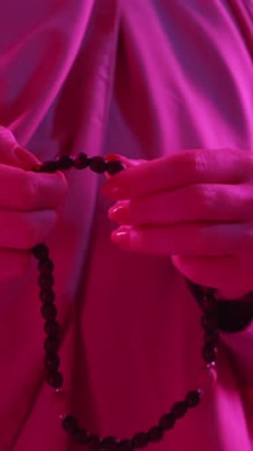 Woman Moves Beads Through Her Fingers
