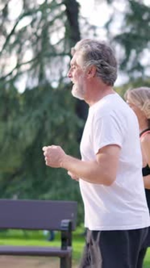 Senior Athletic Couple Jogging Together in a Park