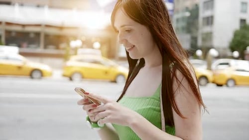 Woman Using Smartphone on Urban Street