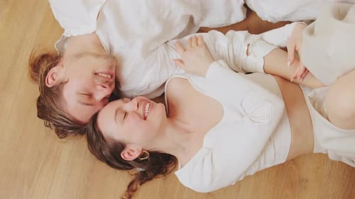 Smiling Couple Lying Together on Floor Indoors