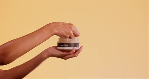 Hands, product and skincare with body scrub for beauty salon, marketing and spa aesthetic in studio