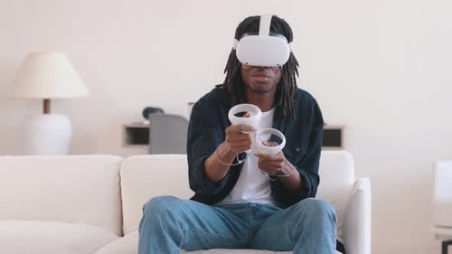 Man using VR Headset Gaming on Couch Indoors