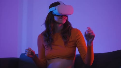 Woman Experiencing Virtual Reality in Neon Lit Room