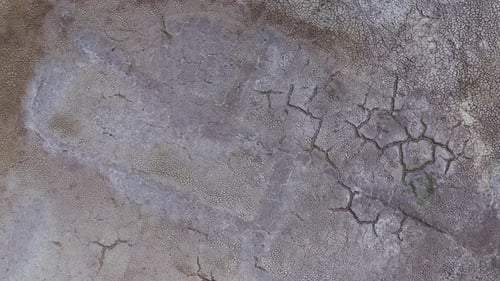 Dry and cracked gray soil ground during drought, viewed from above. top view. earthquake cracking ho