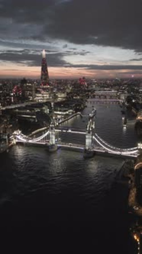 Aerial video of the city of London and the lighthouse bridge in London at night