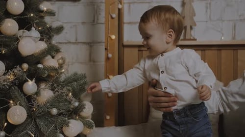 Little boy decorates the Christmas tree