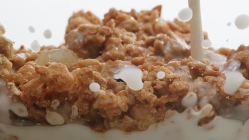Creamy Milk Being Poured onto Crisp Cereal