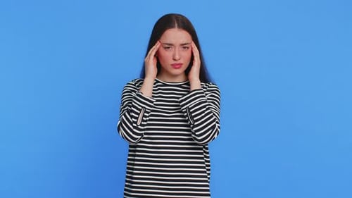 Woman Massaging Temples Against Blue Background
