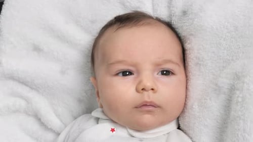 Infant Lying on White Blanket, Close Up