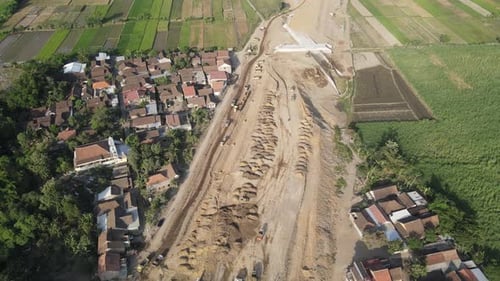 Vue aérienne de la construction de l'autoroute. Un camion à benne basculante passe devant le bâtiment.