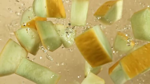 Des morceaux de melon volent sur un fond clair filmés par une caméra à haute vitesse à 1000 images par seconde