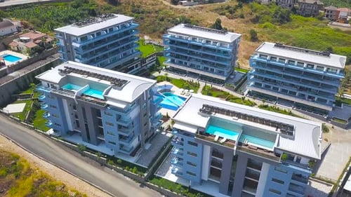 Modern Residential Complex with Rooftop Pools Overlooking Green Hills