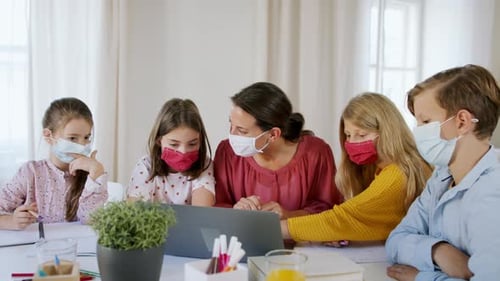 Teacher and Children Learning with Laptop Wearing Masks